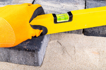 Laying paving stones on sand. Minor paving work in a home environment.