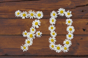 70 birthday flowers on a wooden background