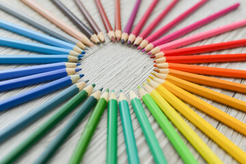 Pencils circle which lies on a wooden background