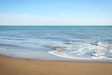Beach and sea landscape in clear sunny day. Foamy water and clear beach nature. Antalya, Turkey.