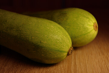 Pair of zucchini isolated on the wooden table. Close up view.