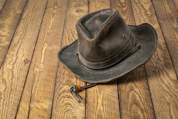weathered outback oilskin hat  on rustic wooden table
