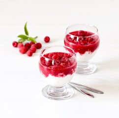 Cottage cheese cream berry dessert with fresh raspberries in a glass on a white background