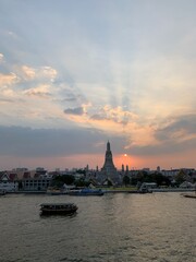 Fototapeta na wymiar Coucher de soleil sur le fleuve et le Wat Arun à Bangkok, Thaïlande