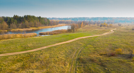 Fototapeta premium Lake with blue water view from the top. Autumn lake shot from a quadrocopter. Lake in the forest
