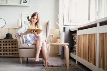 Woman reading a novel relax at home. Quarantine Indoor lifestyle. Leisure indoors entertainment.