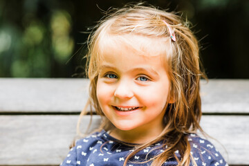 Portrait of happy girl relaxing on bench
