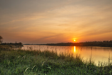 Fototapeta na wymiar Beautiful sunset on the banks of a large river