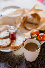 Obraz na płótnie Canvas Delicious fresh tasty continental breakfast. Nutritious healthy rustic food. Crispy aromatic bread, jam, fruits. Mediterranean italian lunch. Moorning cooking. Toast with butter. coffee with cream 