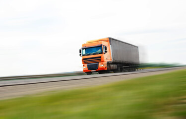 Fototapeta na wymiar Truck with container driving on the asphalt road. Cargo transportation concept. 