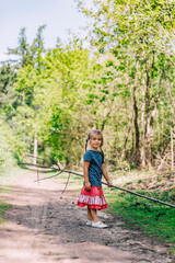 Girl playing with sticks on trail in forest