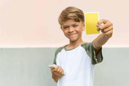 A small boy is holding cards made of paper