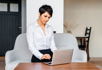 Many stuff to do today in home office. Business woman working from home using her laptop