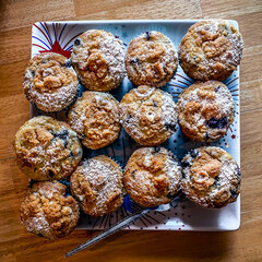 One Dozen blueberry, crumble muffins on patriotic platter with fork on wooden table shot from above looking down.