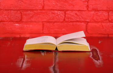 open book on red wooden table