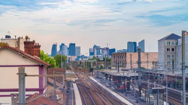 4k timelapse of skyscrapers of Paris business district La Defense on a cloudy summer day and the RER train station. From houilles, west of Paris, France.Camera fixed position