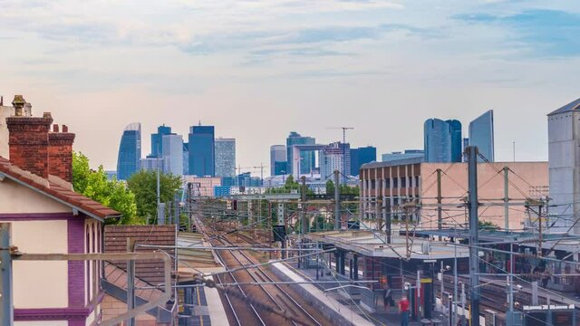 4k timelapse of skyscrapers of Paris business district La Defense on a cloudy summer day and the RER train station. From houilles, west of Paris, France.Camera zooms out