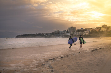 Fototapeta na wymiar Sydney, NSW/Australia: Surfers leaving Bondi beach in the evening