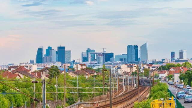 4k timelapse of skyscrapers of Paris business district La Defense on a cloudy summer day and the RER train station. From houilles, west of Paris, France.Camera zooms out