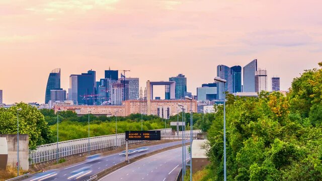 4k timelapse of skyscrapers of Paris business district La Defense on a cloudy summer day and the traffic on highway A14. From houilles, west of Paris, France.Camera zooms out