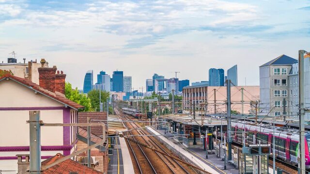 4k timelapse of skyscrapers of Paris business district La Defense on a cloudy summer day and the RER train station. From houilles, west of Paris, France.Camera fixed poition
