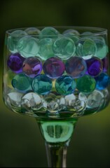 Beautiful aqua hydrogel balls in a green glass in layers. Balls growing in water