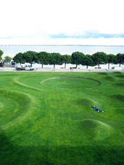 Obraz premium view to Jardim das Ondas in Lisbon, Portugal, on shinny day, with Tejo river and Vasco da Gama bridge as background.