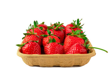 Red vivid ripe strawberries berries laying in organic brown cardboard pallet box. Farm harvest or local food concept. Isolated on white background close up with empty space for text