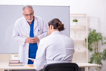 Experienced doctor teaching young male assistant