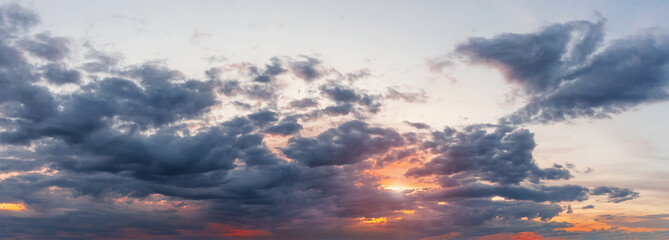 Naklejka na ściany i meble Panorama of a dramatic sky at sunset. Beautiful cloudscape