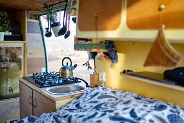 Kettle on stove by bed in motor home