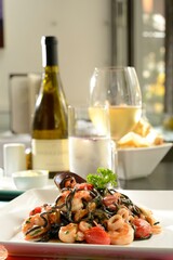 Tagliolini negro com frutos do mar - massa fresca com tinta de lula, camarões, vôngoles, mariscos e molho de tomate