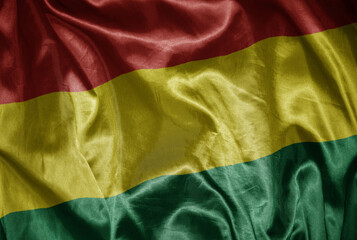 colorful shining big national flag of bolivia on a silky texture.