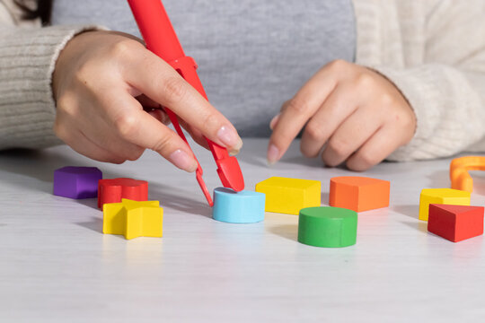 hand using tweezers with blocks