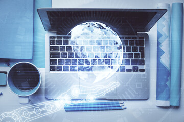 Double exposure of map hologram drawing over study table background with computer. Concept of international network. Top view.