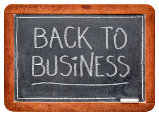 Fototapeta premium back to business - white chalk handwriting on a slate blackboard, business opening after coronavirus covid-19 pandemic and social distancing