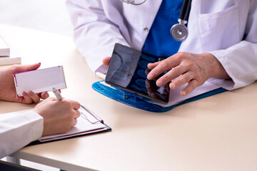 Old male doctor radiologist and his young female assistant in th