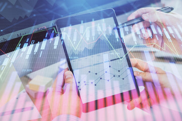 Double exposure of man's hands holding and using a phone and financial chart drawing. Market analysis concept.