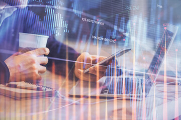 Double exposure of man's hands holding and using a phone and financial graph drawing. Analysis concept.
