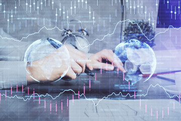 Double exposure of man's hands holding and using a phone and financial graph drawing. Analysis concept.