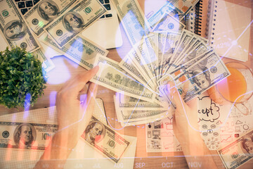 Multi exposure of financial graph drawing hologram and USA dollars bills and man hands. Analysis concept.