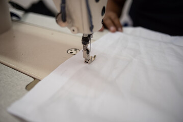 maquina de coser con tela blanca en fabrica