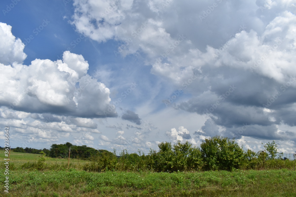 Poster clouds over a field