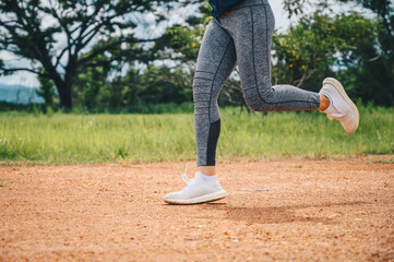 Woman doing workout by running on dirt road (or Trail running). The benefit when running on dirt road can reduce impact on the joints and pushes your muscles in a variety of challenging ways.