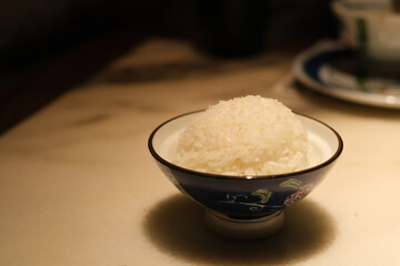 close up a bowl of rice on dining table at dinner. blur background