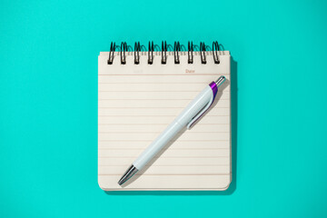 notepad and pen on blue background, top view