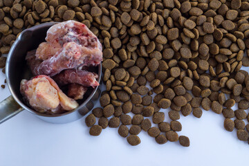 Dry,adult dog food with vitamin and uncooked chicken.Above view,background.