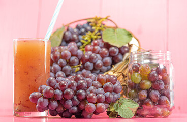 Bunches and grains of the Vitis vinifera variety on pink background