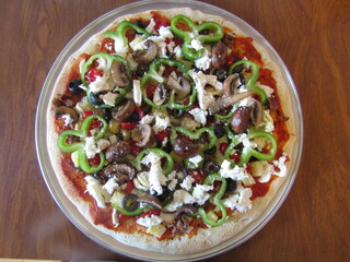 Close up of pizza with green peppers, mushrooms, black olives, and sausage.