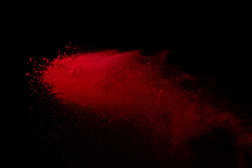Red colored sand splash against black background. 